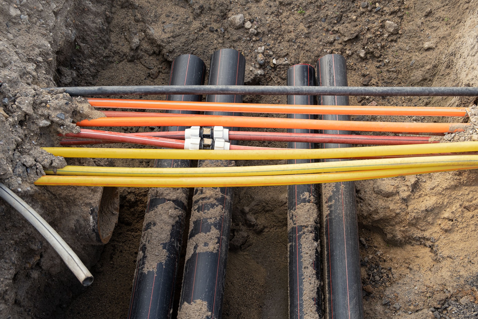 connecting underground cable infrastructure improvement installation. Construction site with A lot of communication Cables protected in tubes. high speed Internet Network cables are buried underground on the street